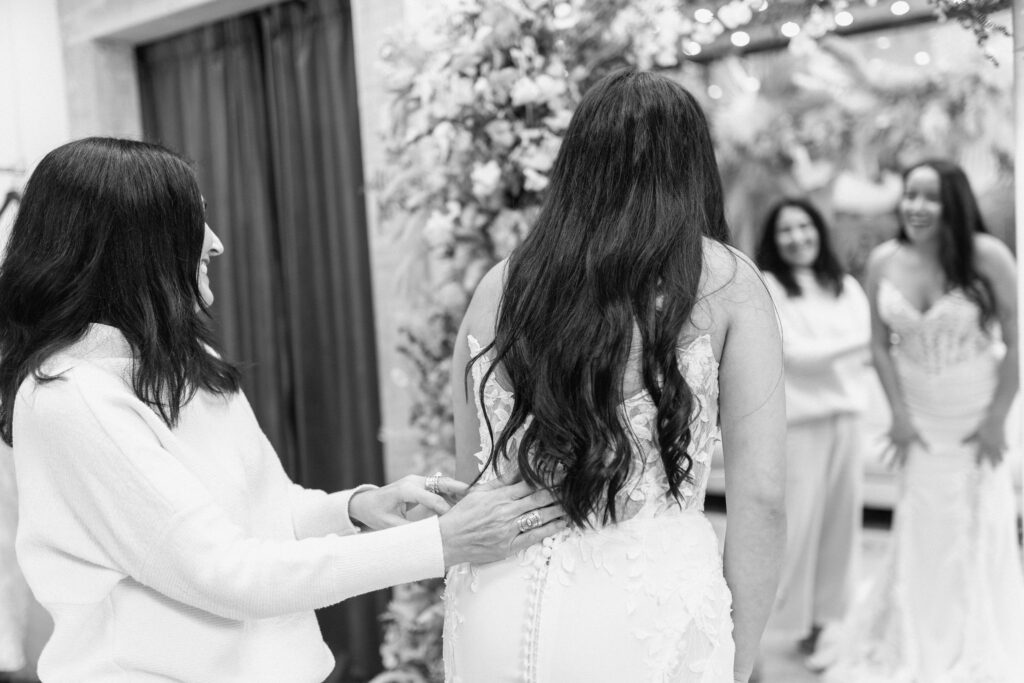 Bride getting into wedding dress at Candè Bridal Boutique Kelowna during emotional bridal fitting moment